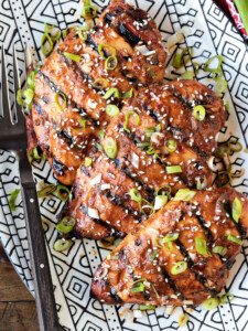 chicken breasts on platter with scallions and sesame seeds