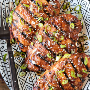 chicken breasts on platter with scallions and sesame seeds