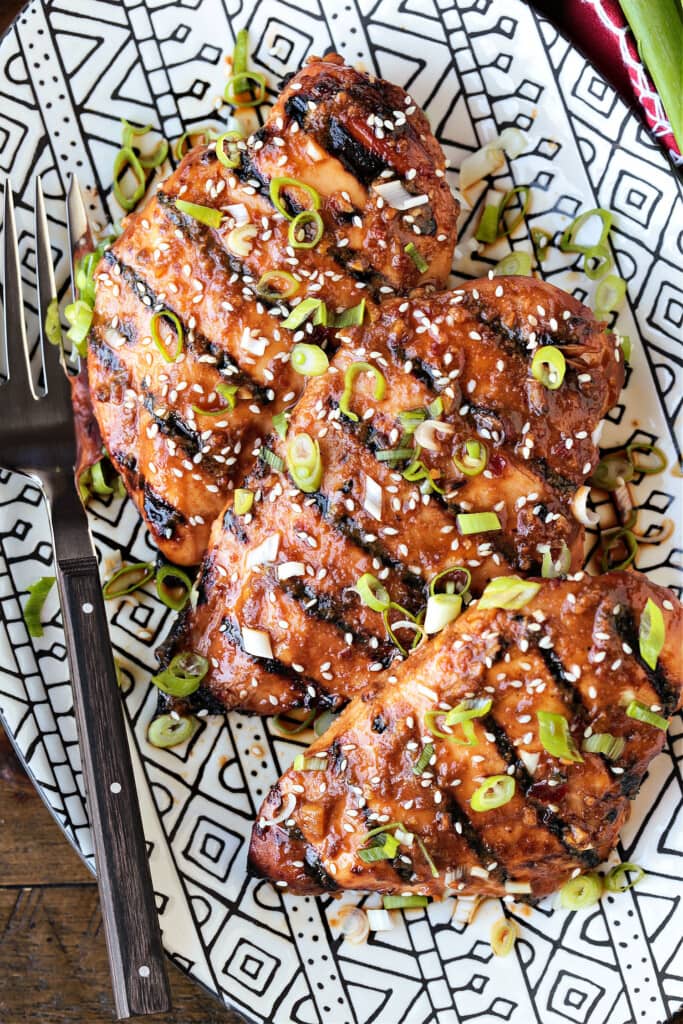 chicken breasts on platter with scallions and sesame seeds