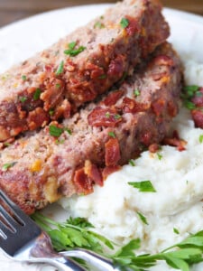 sliced bacon meatloaf on a bed of mashed potatoes