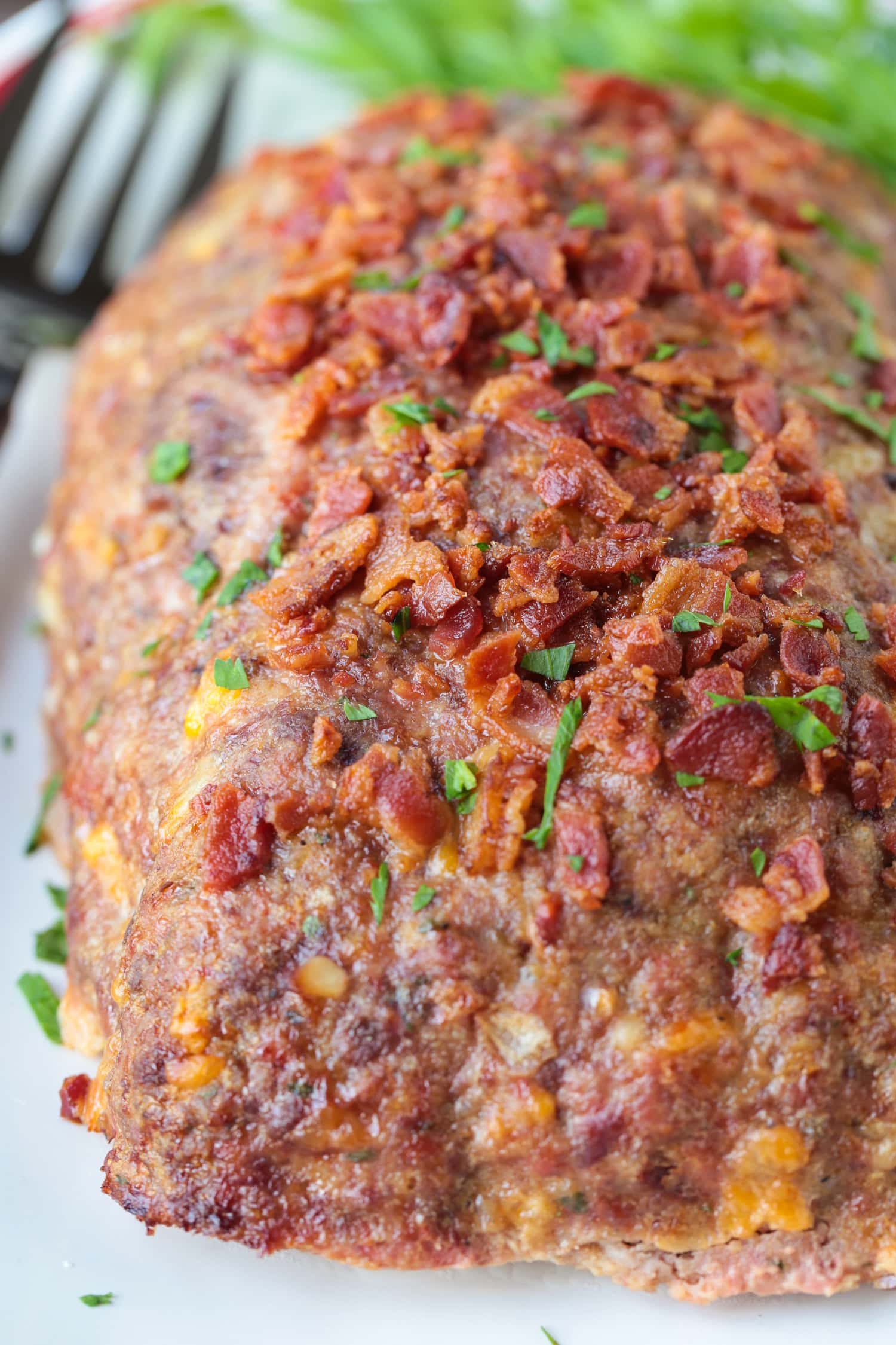 What could be more comforting than a Bacon Meatloaf for dinner? A delicious meatloaf recipe with cheddar cheese and lots of crispy bacon! bacon meatloaf on platter