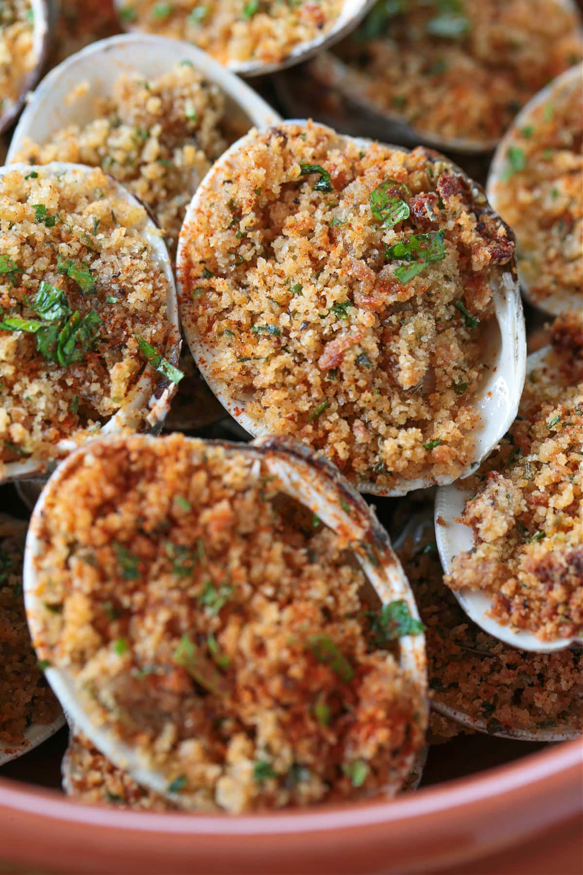 Baked Clams are always a hit! Fresh, steamed clams topped with a buttery breadcrumb topping. A delicious seafood appetizer or dinner! clams in bowl with breadcrumb topping
