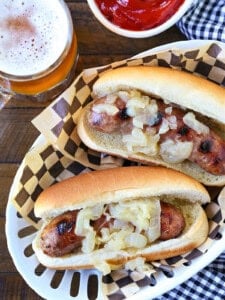 bratwurst with onions in basket with beer and ketchup