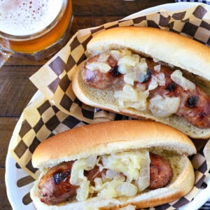 bratwurst with onions in basket with beer and ketchup
