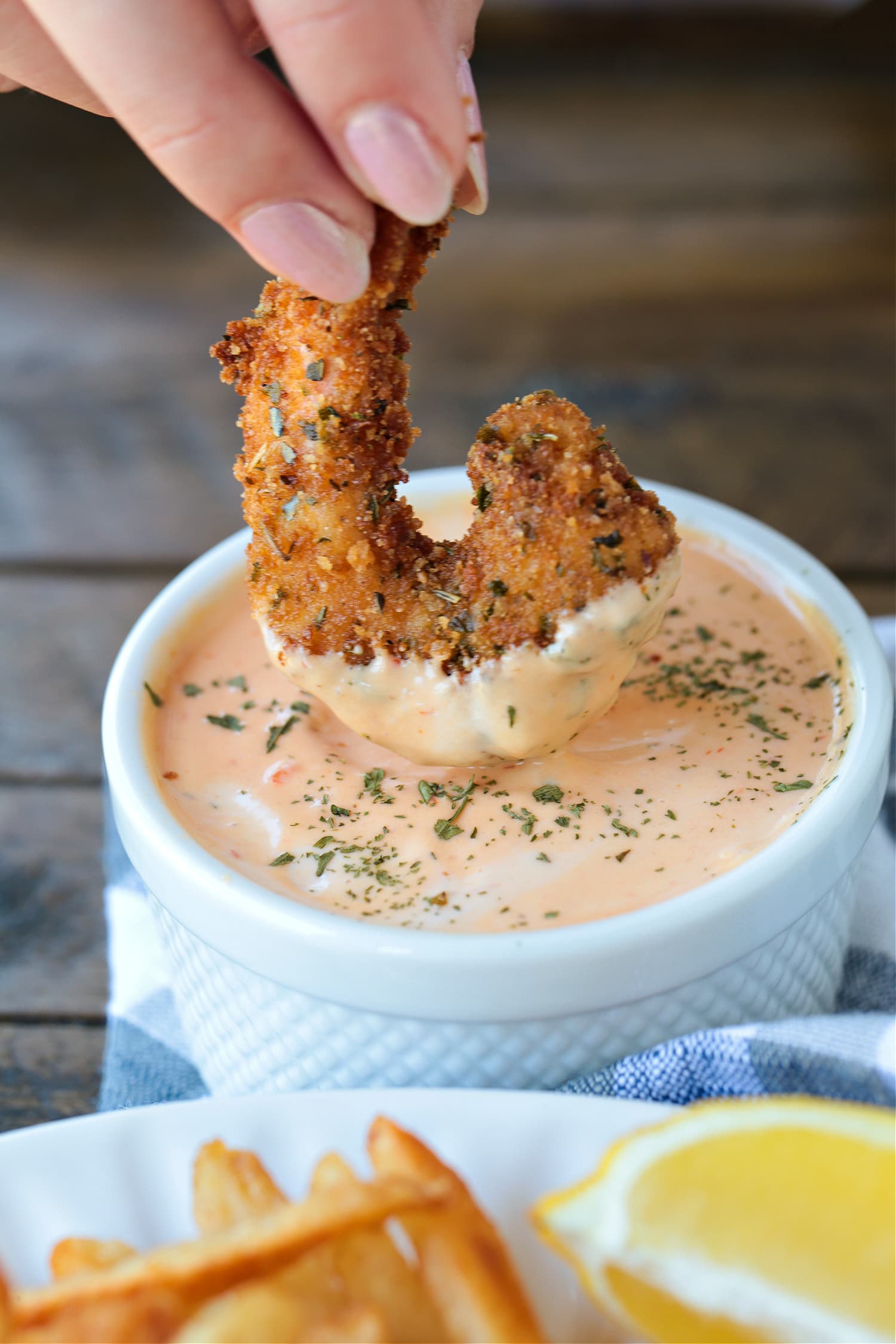 breaded shrimp dipping into sauce