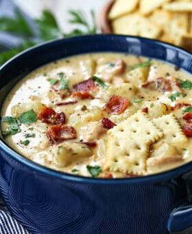 clam chowder in a bowl with crackers on top