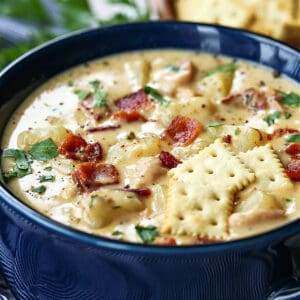 clam chowder in a bowl with crackers on top