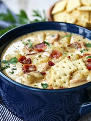 clam chowder in a bowl with crackers on top