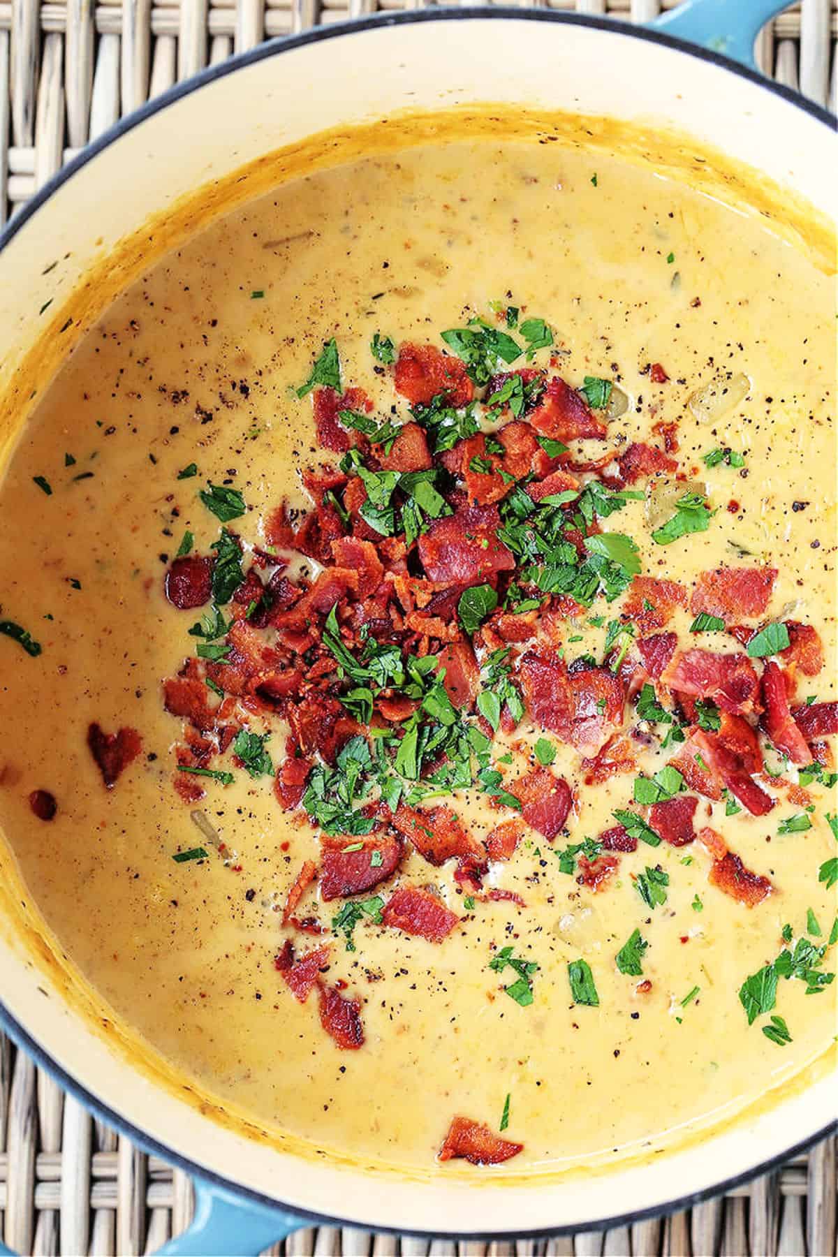 clam chowder in a pot topped with bacon