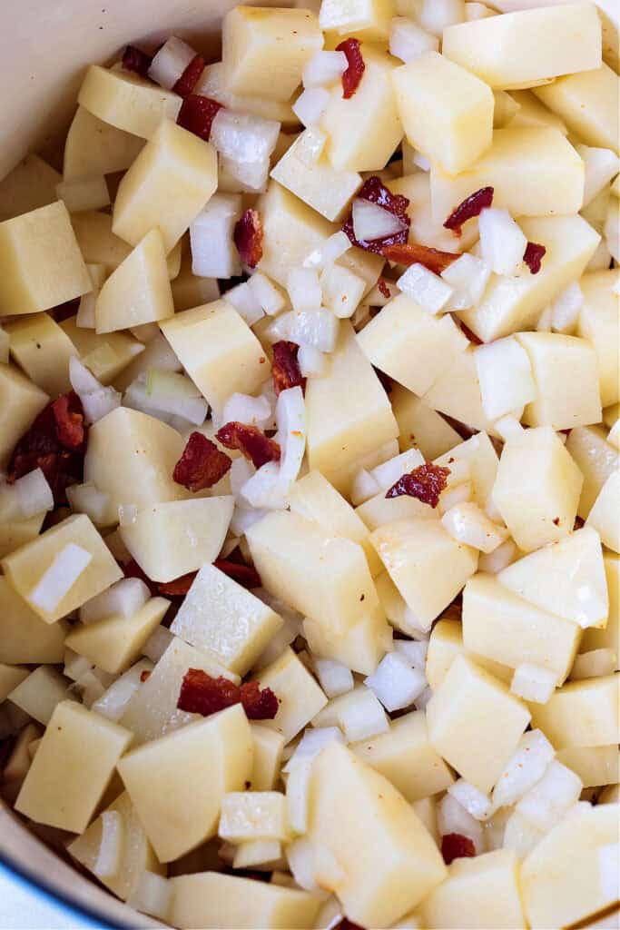 cubed potatoes in a pot with onion and bacon