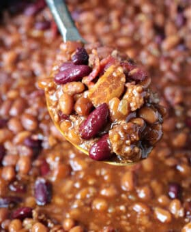 baked beans with ground beef and bacon on serving spoon