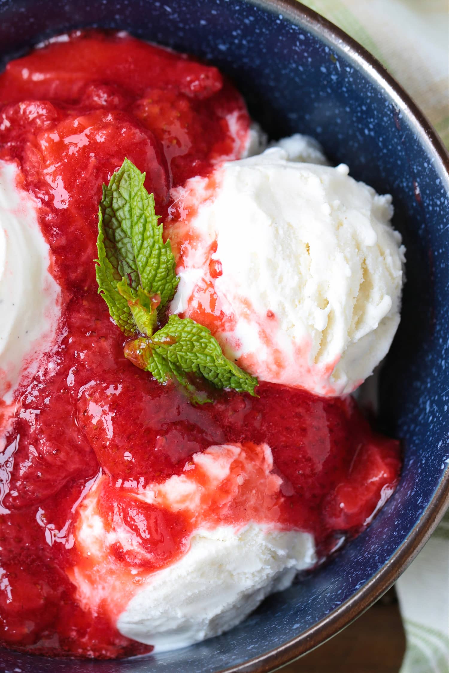 ice cream in a bowl with mint and strawberry sauce