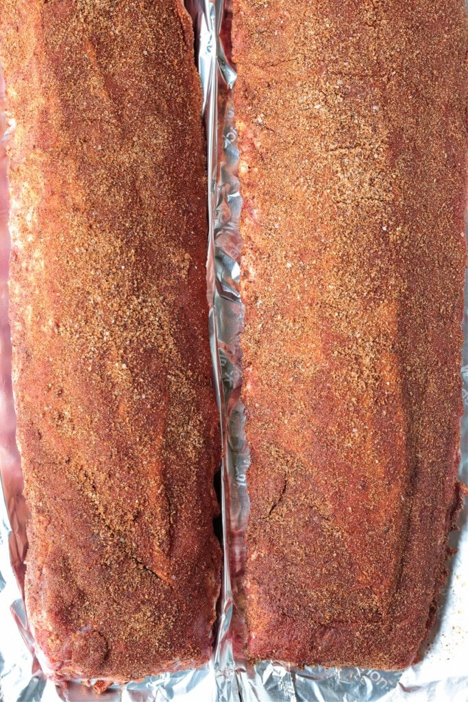 The BEST BBQ Ribs Recipe for easy dinner nights and parties! Seasoned with our signature dry rub, they're perfectly tender and so addicting. dry rubbed racks of ribs on foil