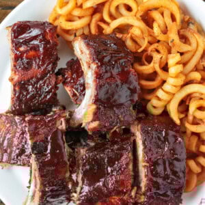 sections of bbq ribs on plate with curly fries
