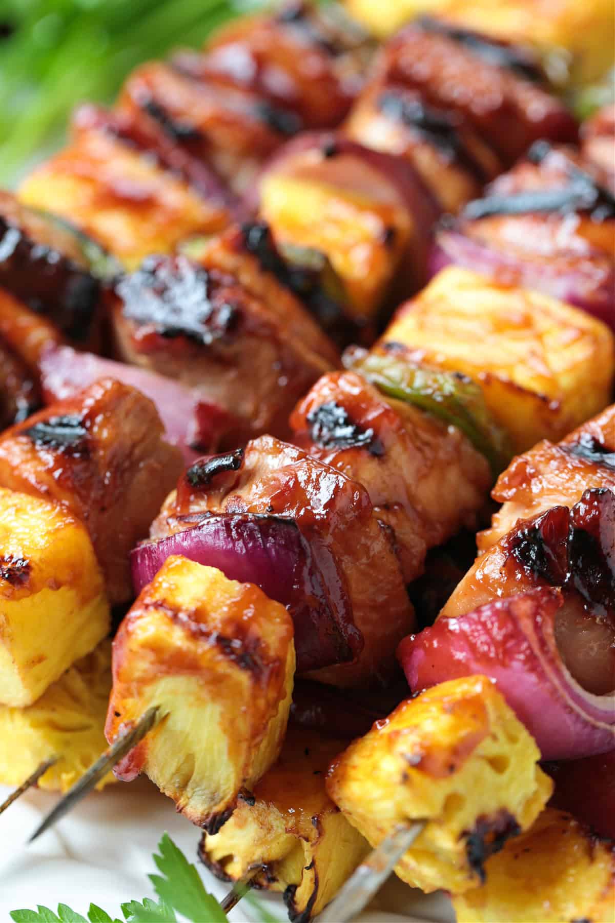 Chicken Pineapple Kabobs are a fun and tasty dinner! Sweet, grilled pineapple combined with juicy, marinated chicken and roasted vegetables. grilled chicken kabobs stacked on platter