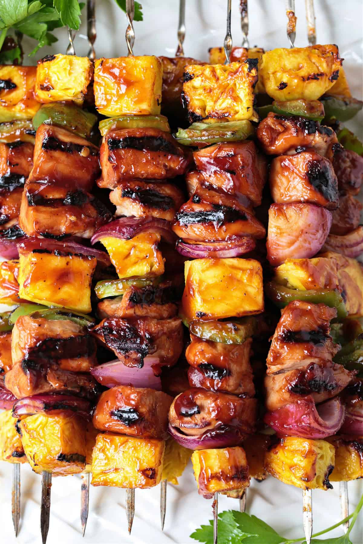 Chicken Pineapple Kabobs are a fun and tasty dinner! Sweet, grilled pineapple combined with juicy, marinated chicken and roasted vegetables. grilled chicken and pineapple kabobs on skewers