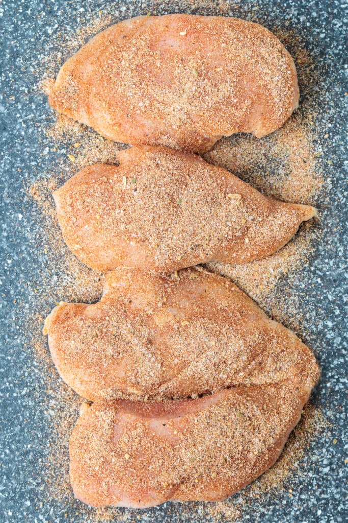 chicken breasts on board with seasoning