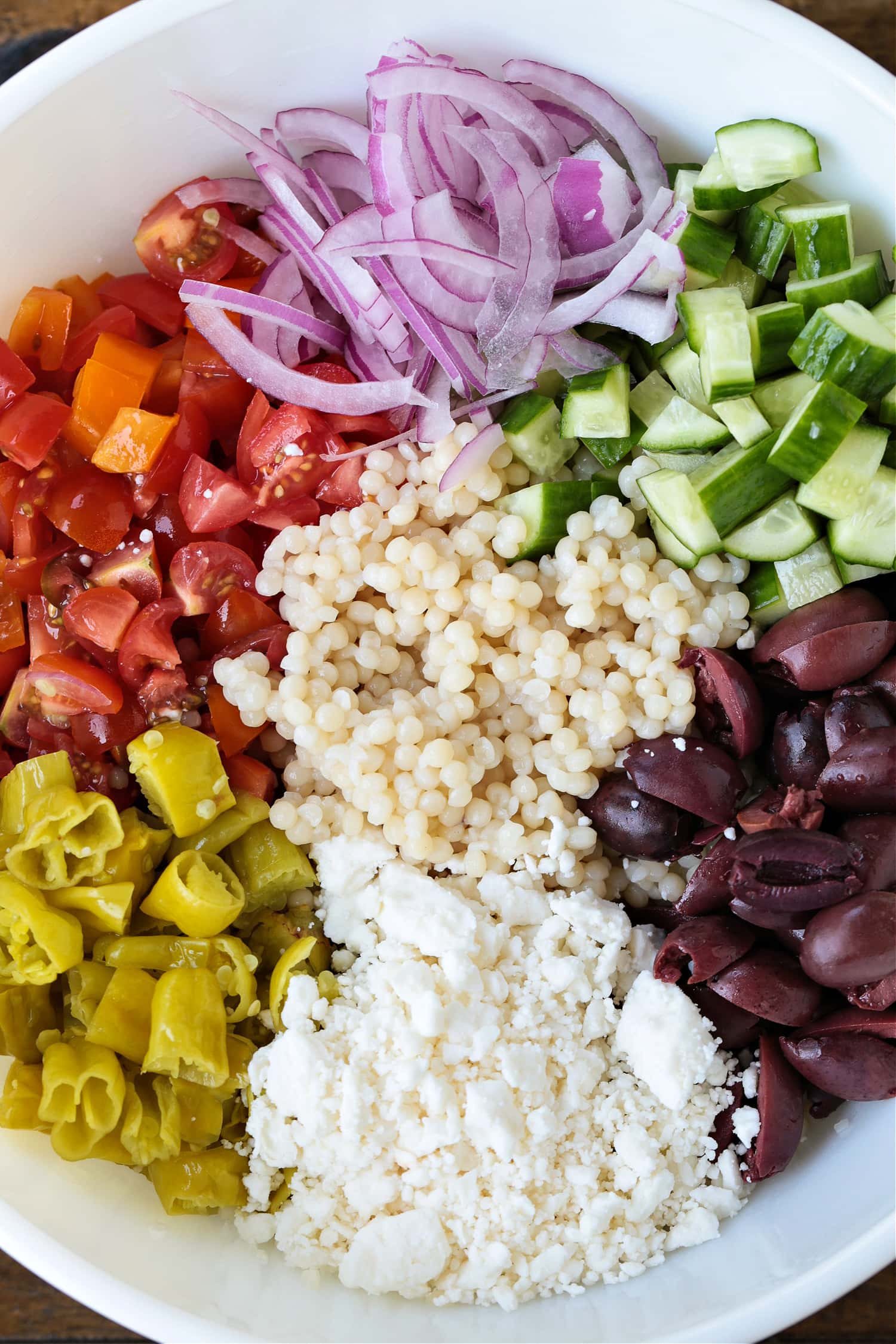 ingredients for greek couscous salad in bowl