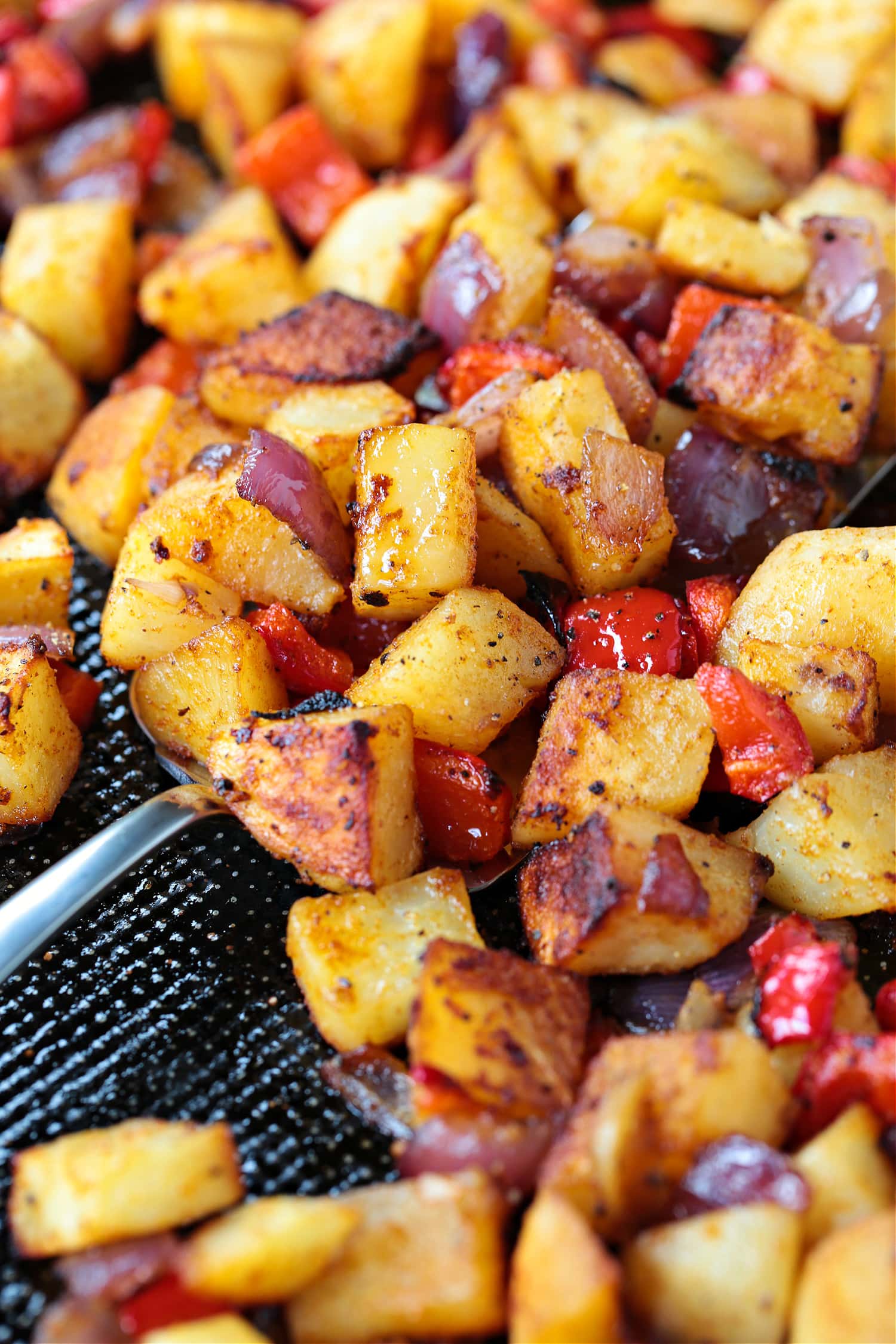 These Crispy Breakfast Potatoes are perfectly seasoned and roasted to perfection. A tasty side dish for breakfast, brunch or dinner! breakfast potatoes on sheet pan with spatula