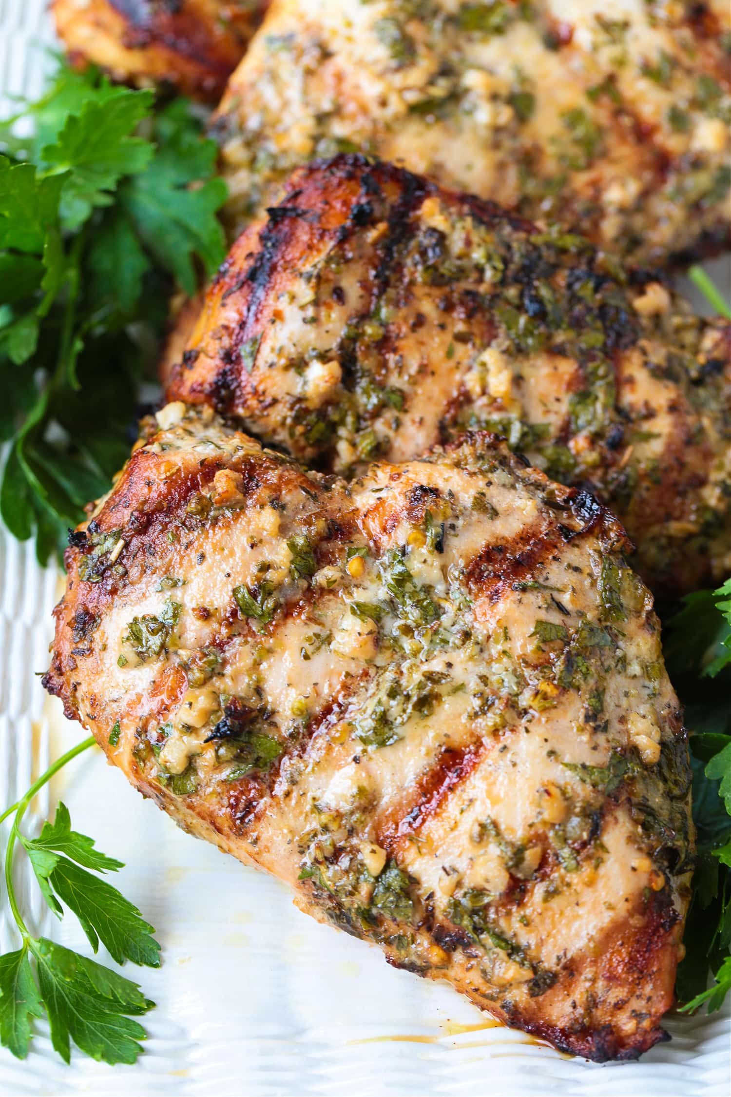 Marinated, grilled chicken breasts on a platter