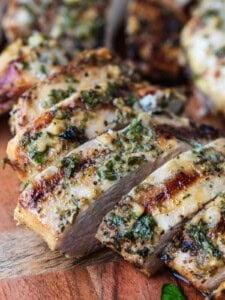 sliced chicken breast on cutting board with marinade