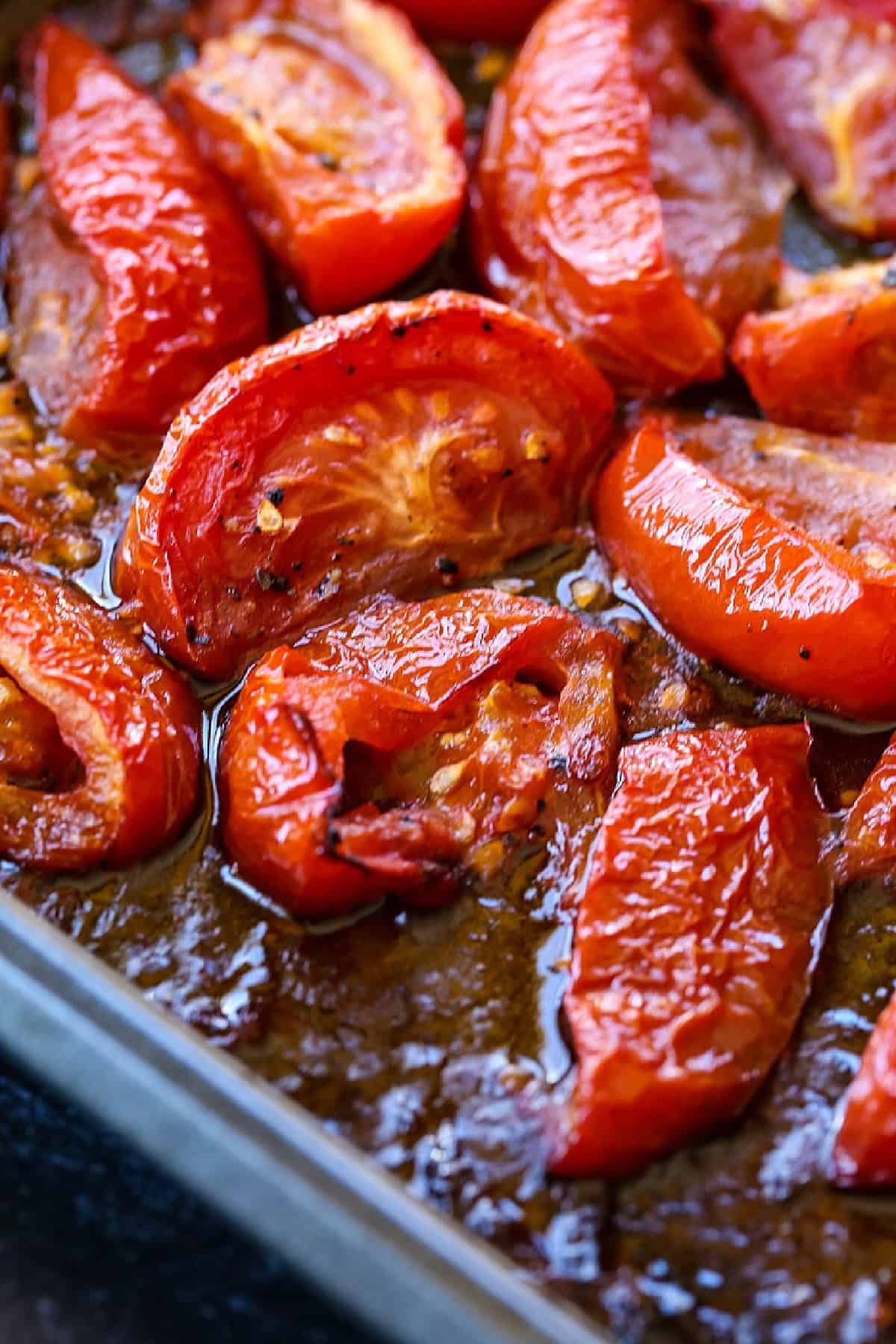 Roasted Tomato Basil Soup is one of our favorite comfort foods! Flavorful, roasted tomatoes combined with basil and nutty parmesan cheese. roasted tomato wedges on baking sheet