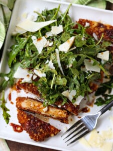 Chicken Milanese on a white plate with fork