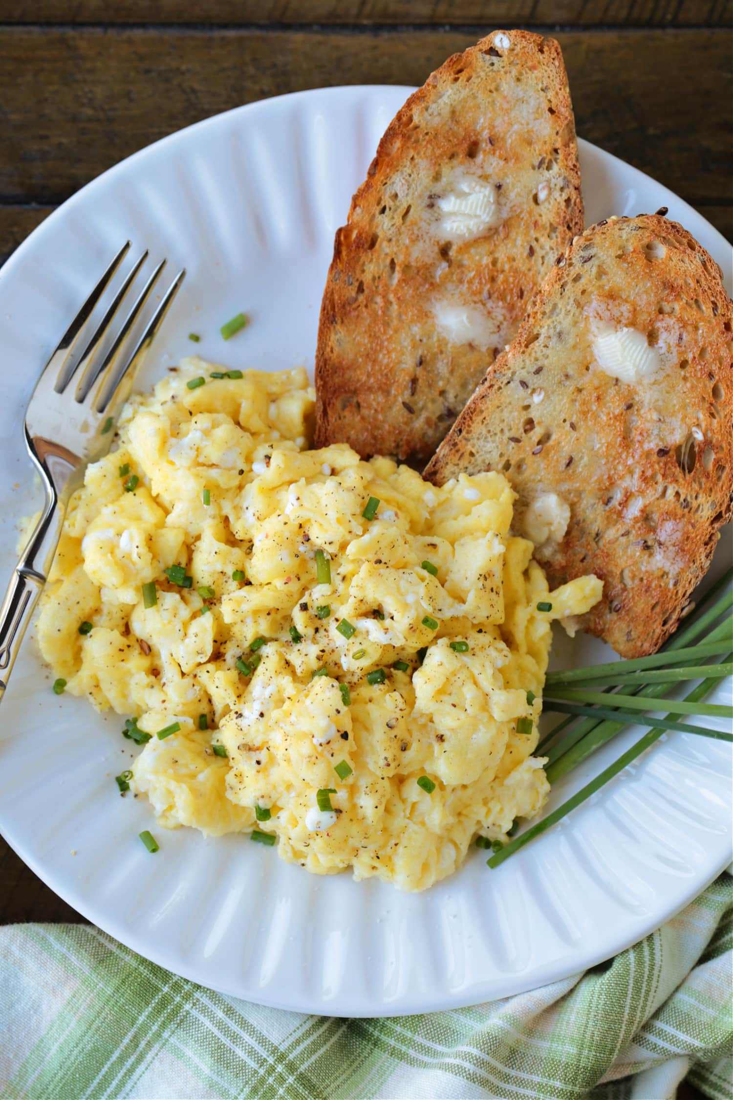 scrambled eggs with cottage cheese on a plate with toast