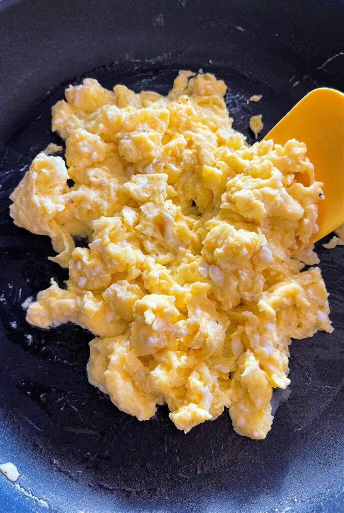 cooked scrambled eggs in skillet with spatula