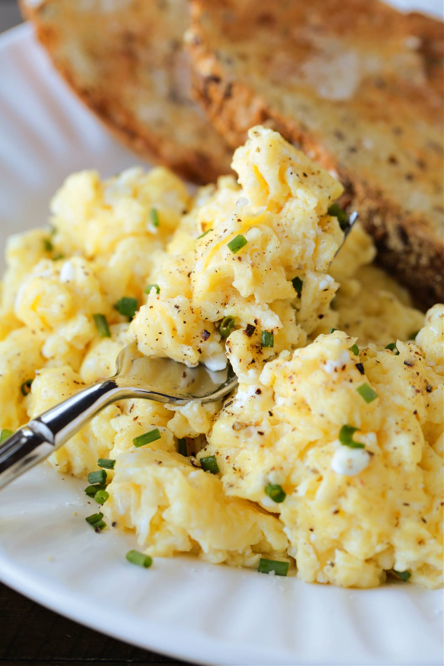 scrambled eggs with cottage cheese and chives on fork