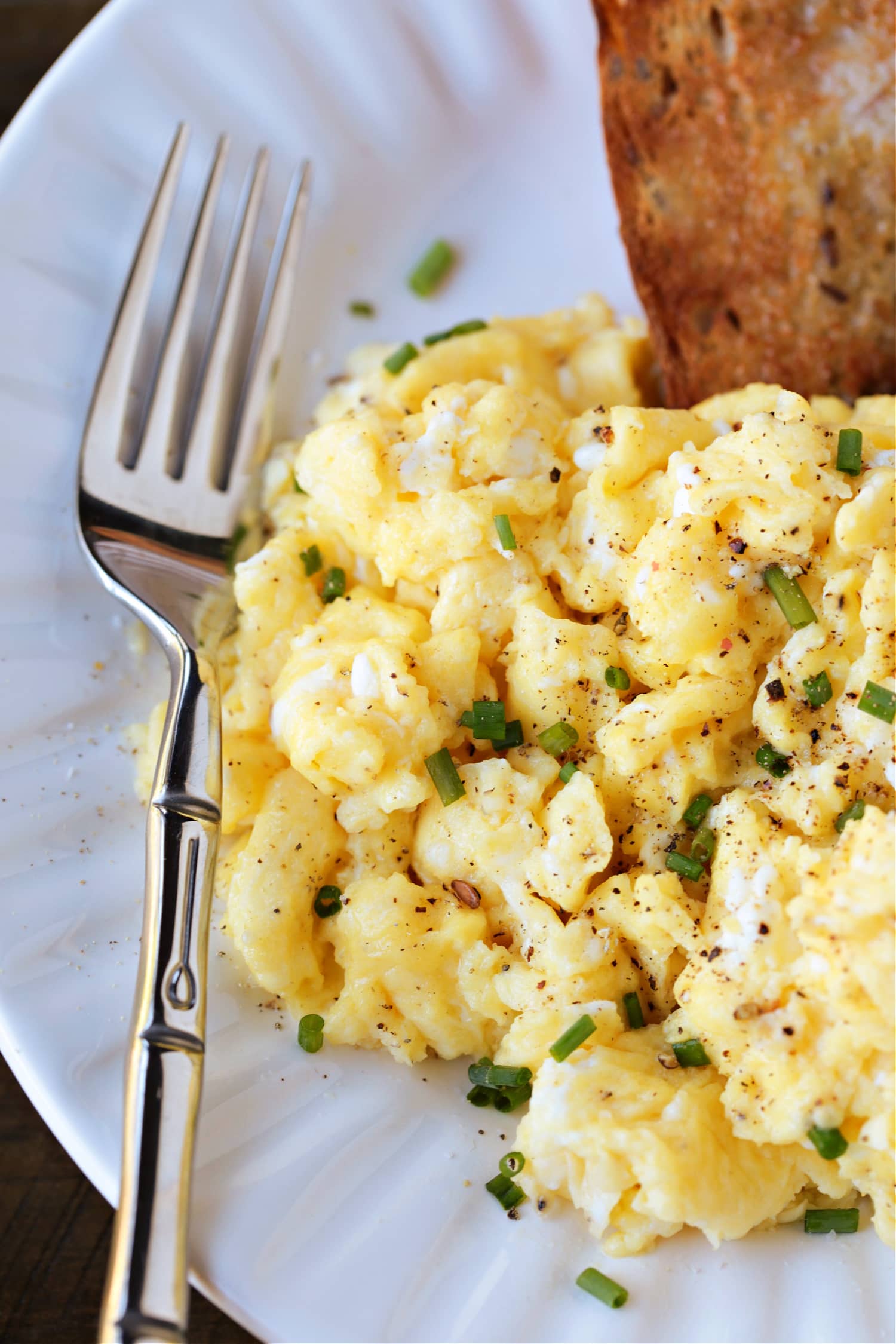 cottage cheese scrambled eggs on plate with toast and fork