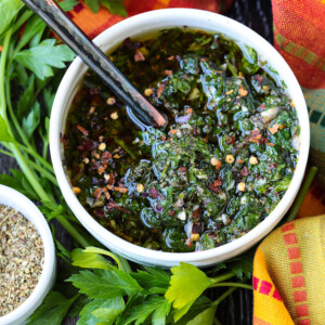 chimichurri sauce in bowl with spoon and colorful napkin