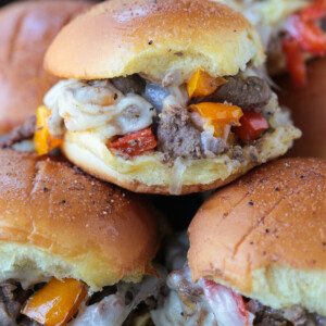 philly cheesesteak sliders stacked on plate