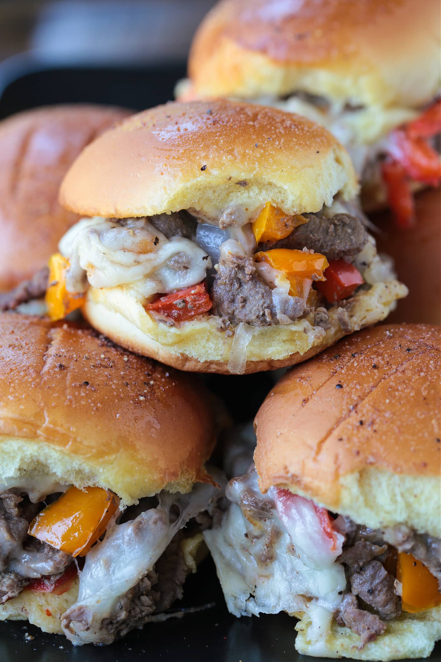 philly cheesesteak sliders stacked on plate