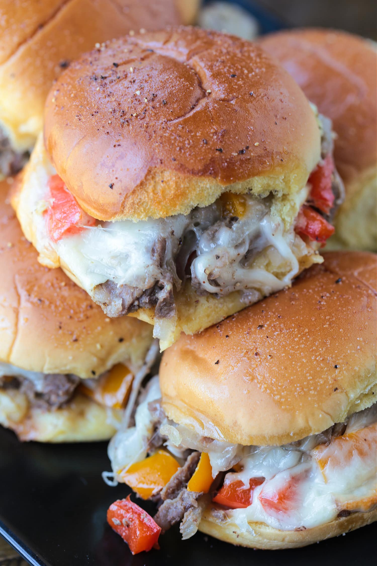 philly cheesesteak sliders stacked on pan