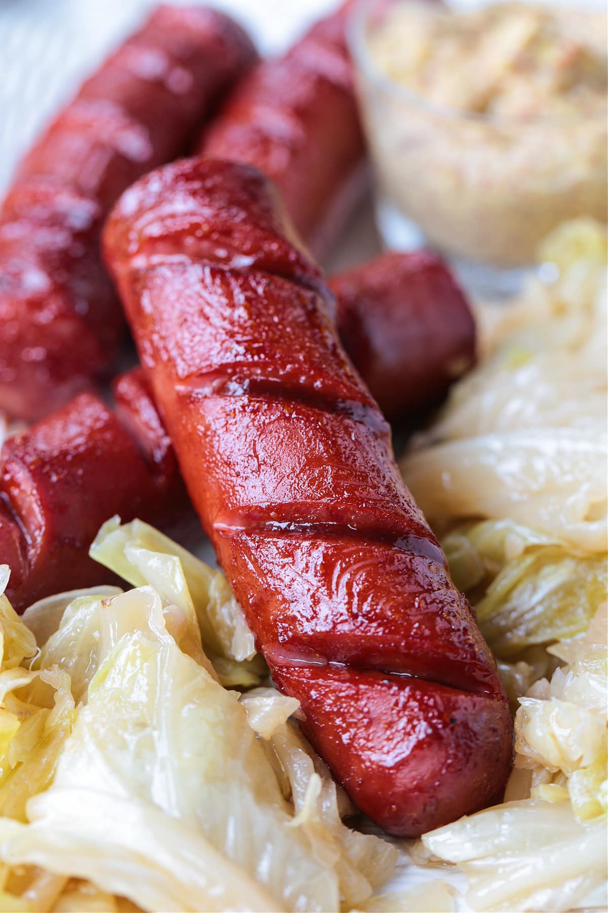 Air Fryer Kielbasa turns out crispy on the outside and super juicy on the inside! Just two ingredients and less than 10 minutes to make! scored kielbasa basted with barbecue sauce