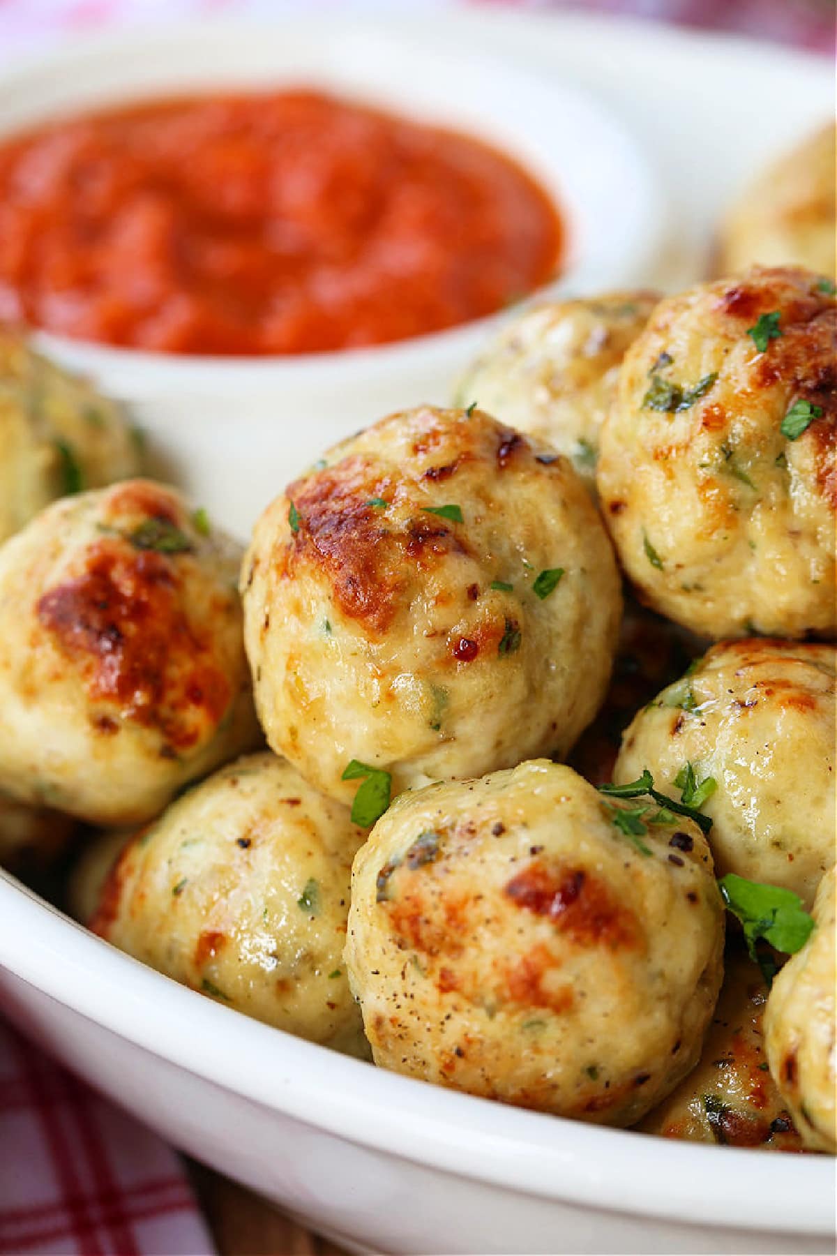 chicken meatballs in a white bowl with marinara sauce