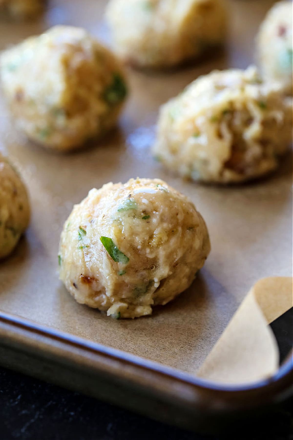 ground chicken meatballs on a baking sheet before going in the oven