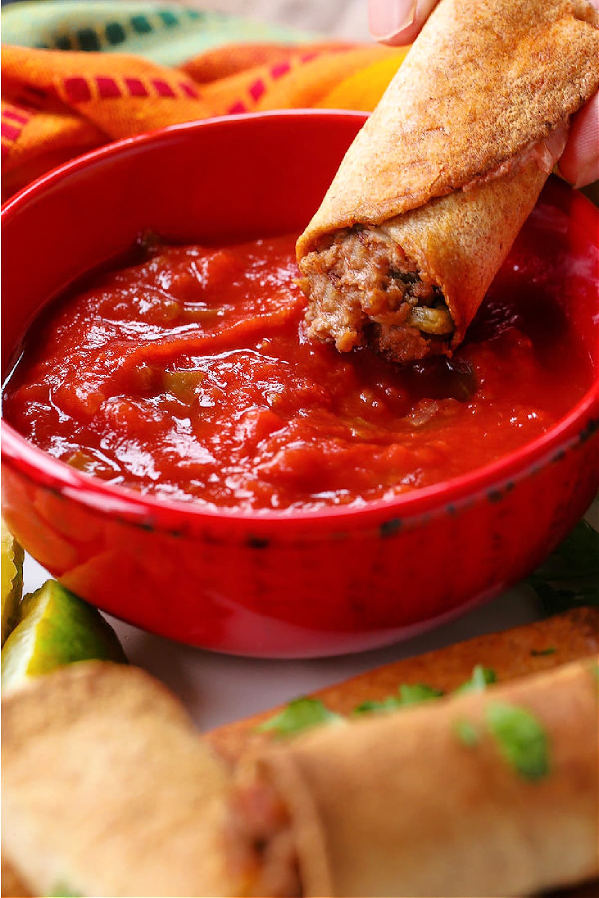 beef taquito dipping into salsa