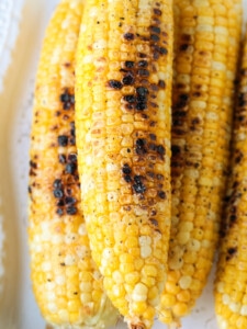 grilled corn on the cob on white platter