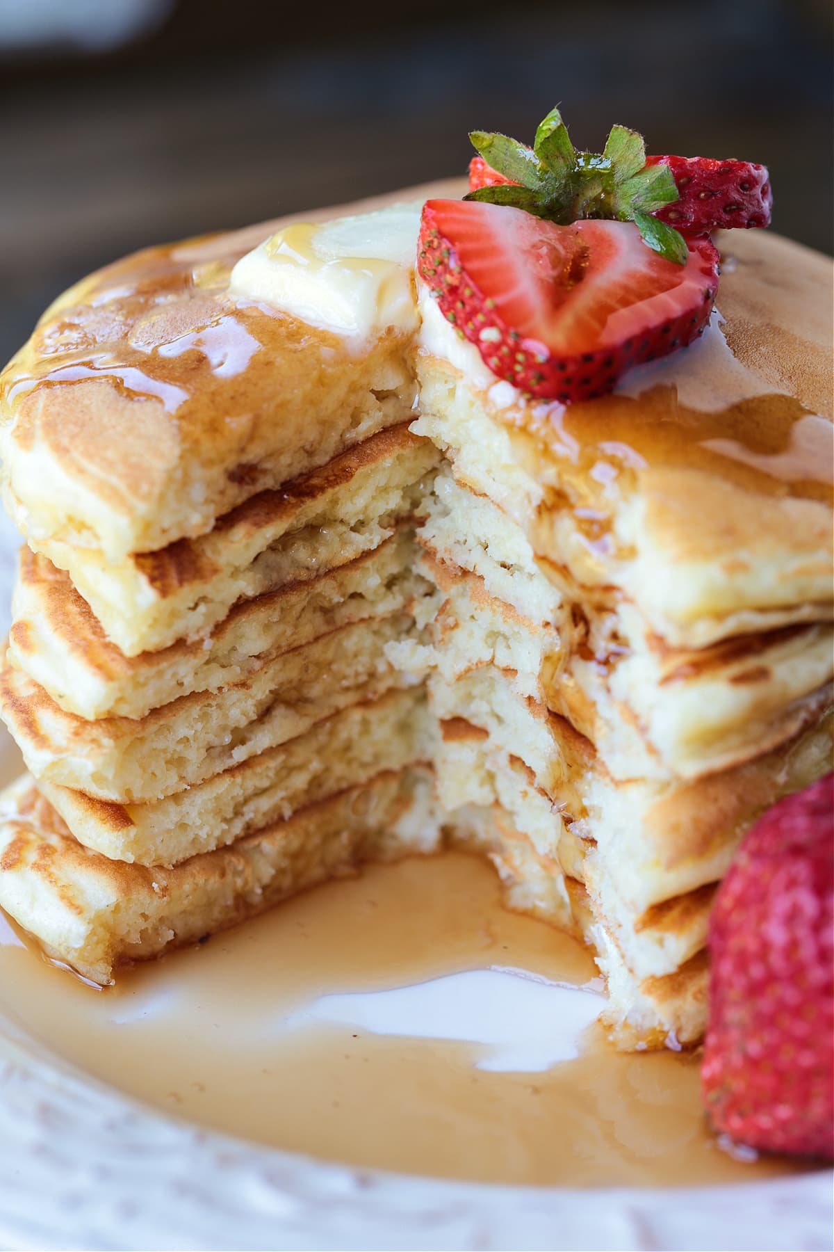 cottage cheese pancakes stacked on a plate with a wedge cut out