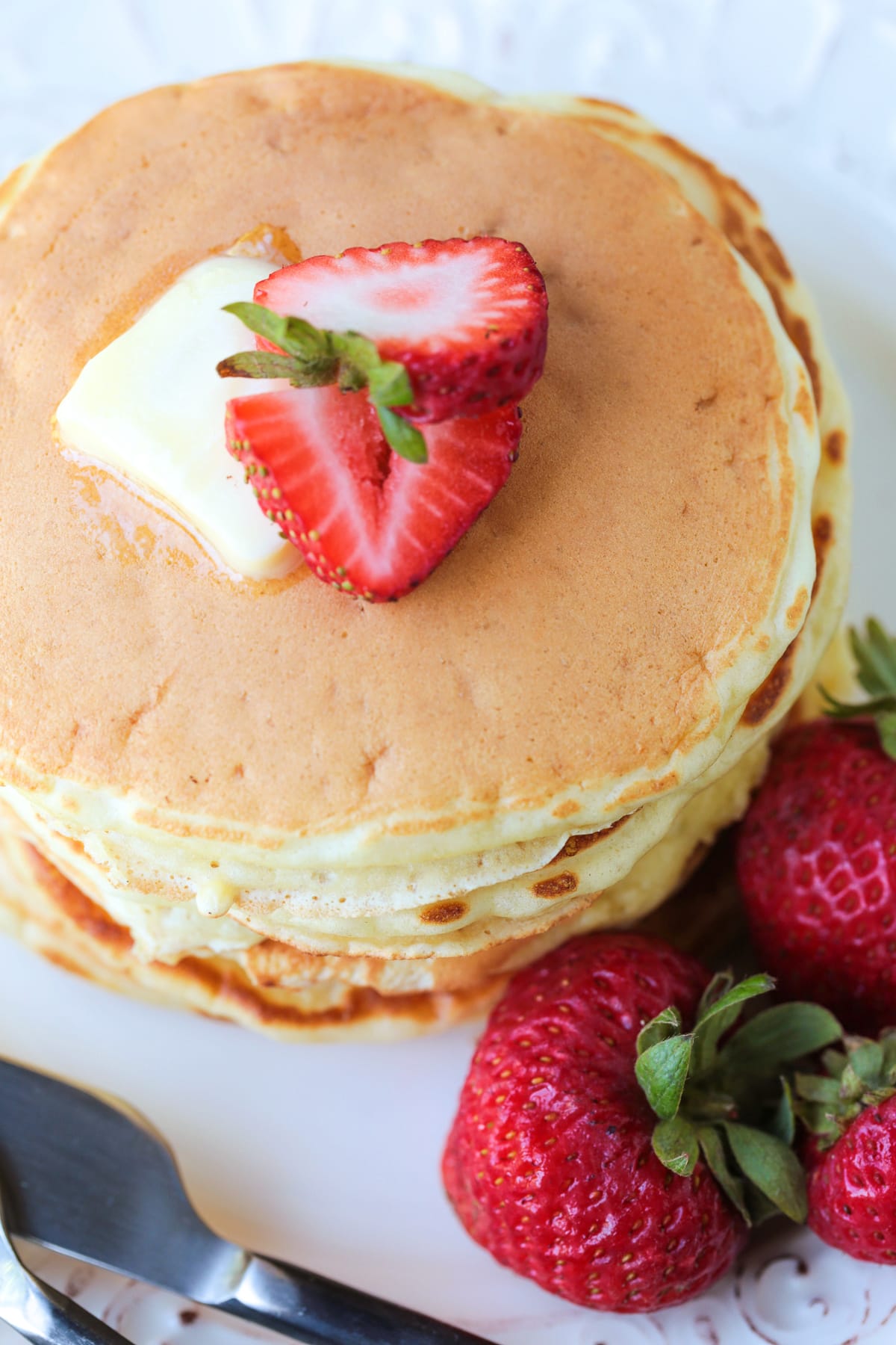 pancakes stacked on a plate with strawberries