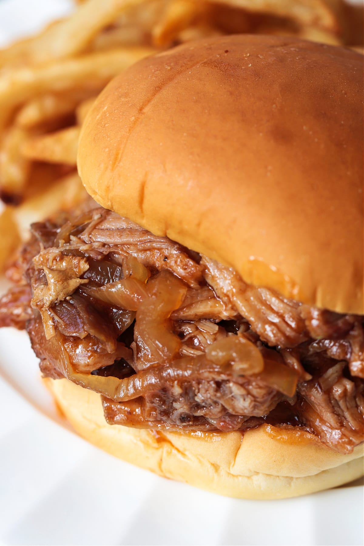 Dr. Pepper Pulled Pork is sweet, savory and crazy delicious. Classic cherry soda caramelizes and tenderizes this addicting slow cooker pork! dr. pepper pulled pork sandwich with french fries