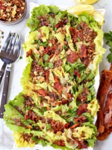 escarole salad on white platter with forks