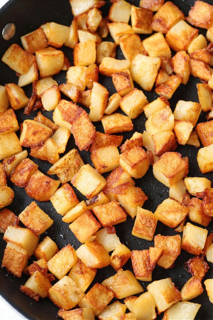 browned, diced potatoes in skillet