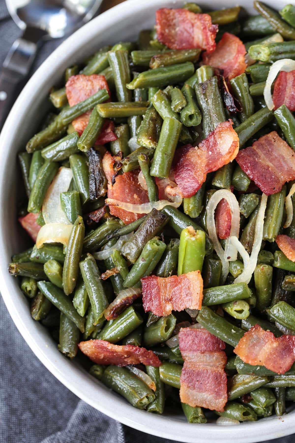 green beans in a bowl with bacon and onions