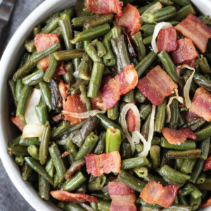 green beans with bacon and onions in a bowl with spoon