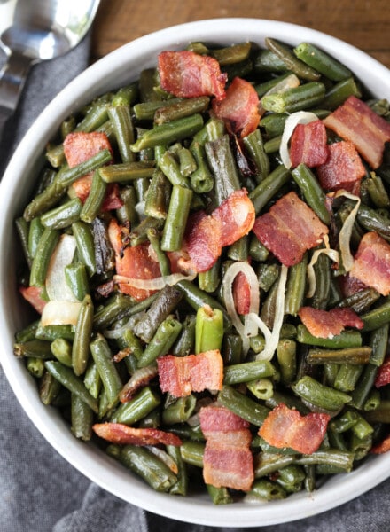 green beans with bacon and onions in a bowl with spoon