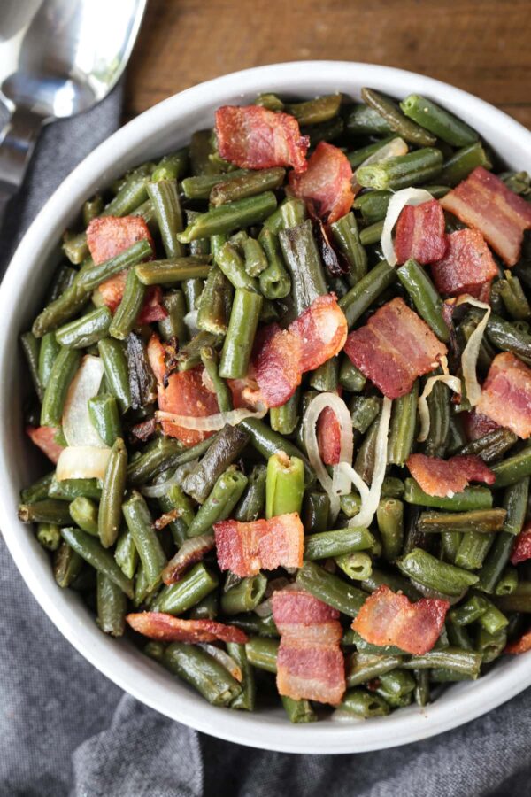 green beans with bacon and onions in a bowl with spoon