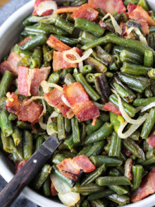 green beans with bacon and onions in bowl with spoon